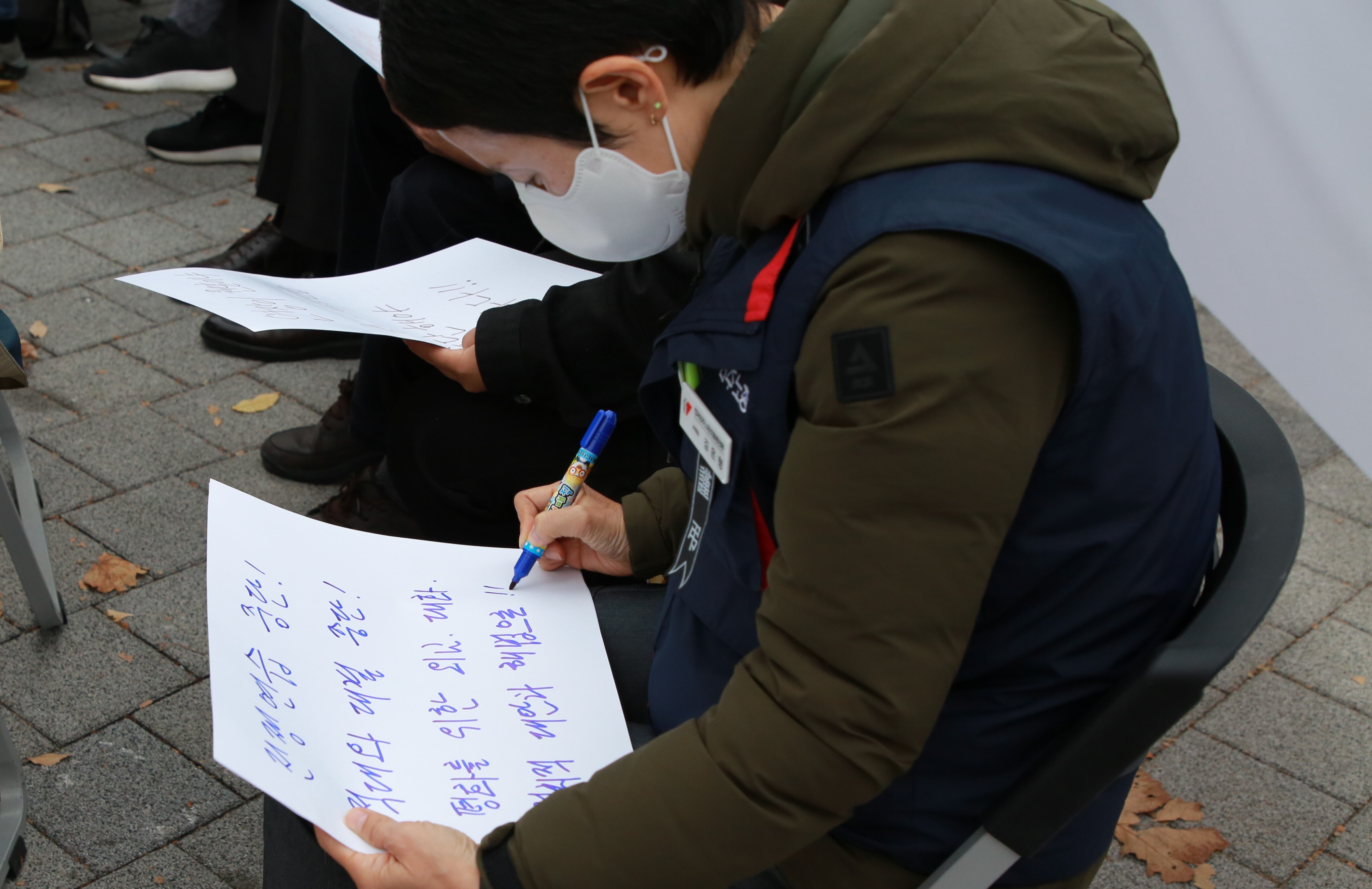 14.참가자들이 손팻말뒤에 자신의 요구를 담는 글을 써서 공개하는포퍼먼스를 진행하고 있다..JPG